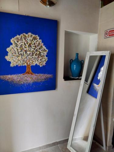 a painting of a tree hanging on a wall at Casabella in Ginosa