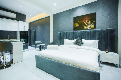 a bedroom with a large bed and a kitchen at Accra Luxury Apartments @ Silicon Square in Accra