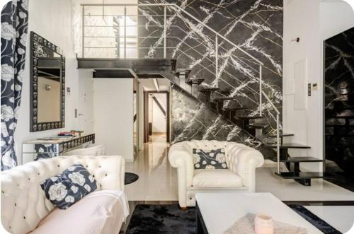 - un salon avec deux chaises blanches et un escalier dans l'établissement Villa cannes vue mer centre croisette 5 min du palais des festival, à Cannes