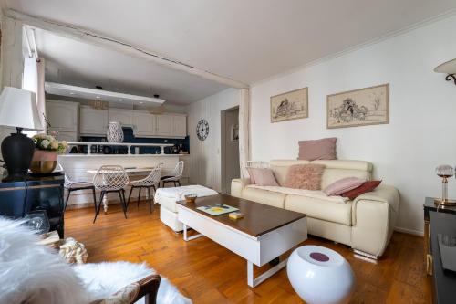 un salon avec un canapé et une table dans l'établissement Heart of Montmartre Air conditioned apartment, à Paris