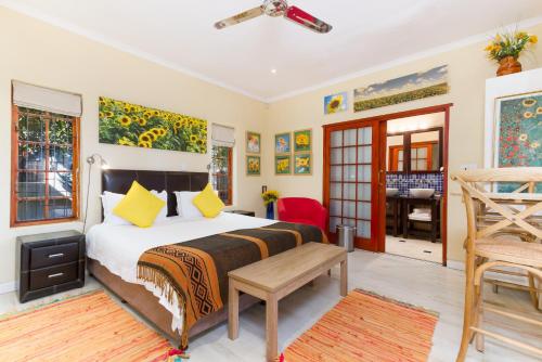 a bedroom with a bed with yellow pillows at Kleinbosch Lodge in Stellenbosch