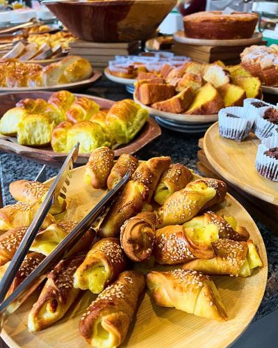 a table topped with plates of pastries and breads at MOVA Hotel D'oeste - Localizado em frente a Praça Principal da Cidade, na área Central - Pé na Praça in Poços de Caldas