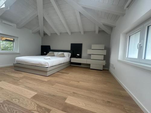 a white bedroom with a bed and a window at Luxury way Aria in Povoletto