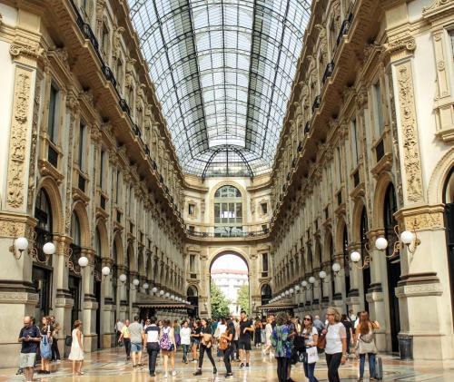 a group of people walking in a building with a glass ceiling at 10' from Malpensa & transfert on demand in Casorate Sempione