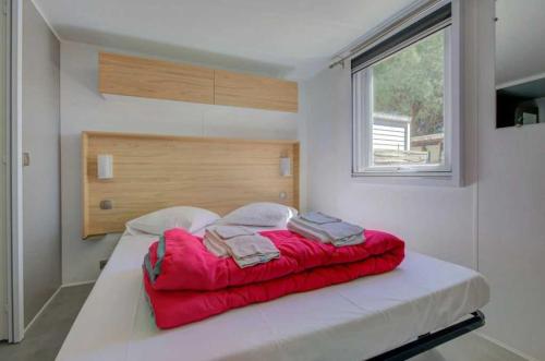 ル・グロー・ダグドにあるCamping 4 étoiles - Piscine - ccbbecdの赤い毛布が掛けられた大きなベッドのある寝室