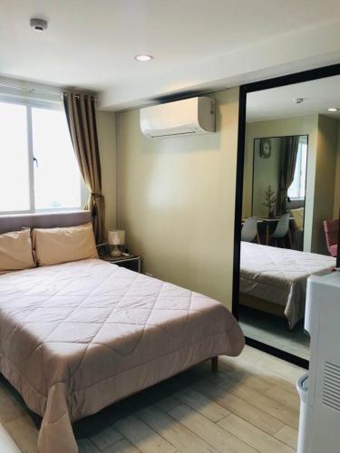 a bedroom with a bed and a large mirror at Cityscape Grand Tower Condo, studio unit in Cebu City