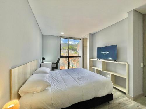 a bedroom with a large bed and a window at New Cozy and Modern Gym Coworking Terrace in Bogotá