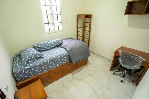 una camera da letto con un letto, una scrivania e una sedia di Villa Remboelan Shariah Guest House a Palur