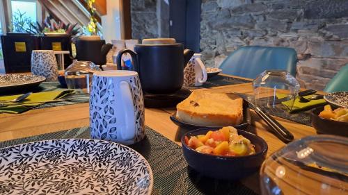 a wooden table with plates of food on it at Moulin de Kervegan in Plouzélambre