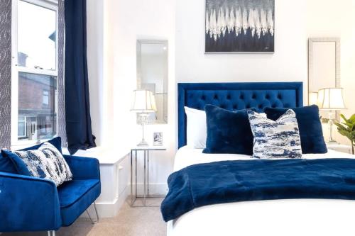 a bedroom with a blue bed and a blue chair at Balfour House in Etruria