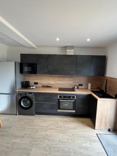 - une cuisine avec des armoires noires et un lave-vaisselle dans l'établissement Appartement T2 Porticcio, à Porticcio