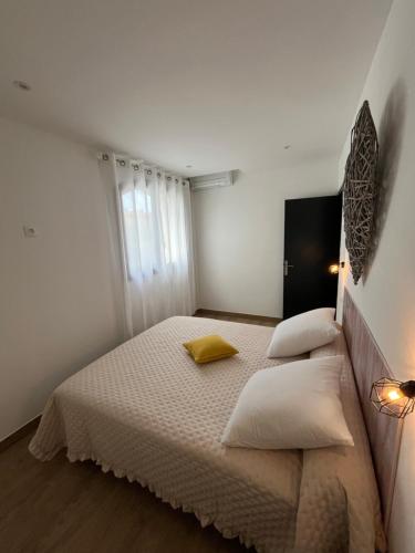 - une chambre blanche avec un lit et deux oreillers dans l'établissement Appartement T2 Porticcio, à Porticcio