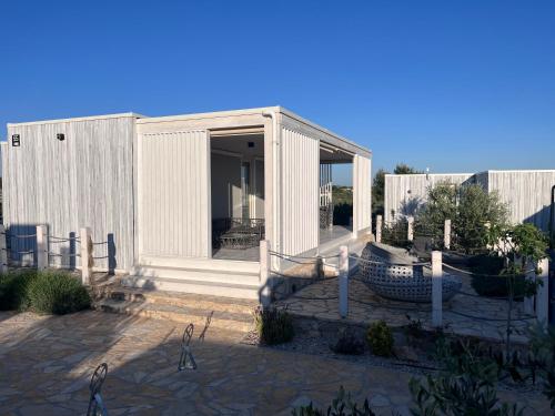 ein kleines weißes Gebäude mit einer Glastür in der Unterkunft BUQEZ RESORT - Villa 55 in Drage