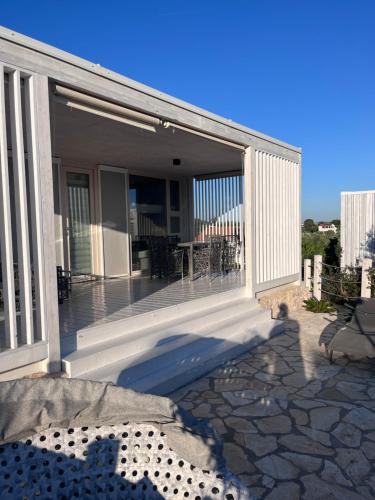 eine überdachte Veranda eines Hauses mit Terrasse in der Unterkunft BUQEZ RESORT - Villa 55 in Drage