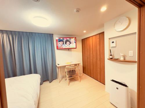 a bedroom with a bed and a desk in it at 阿久津ハイツ102 in Tokyo