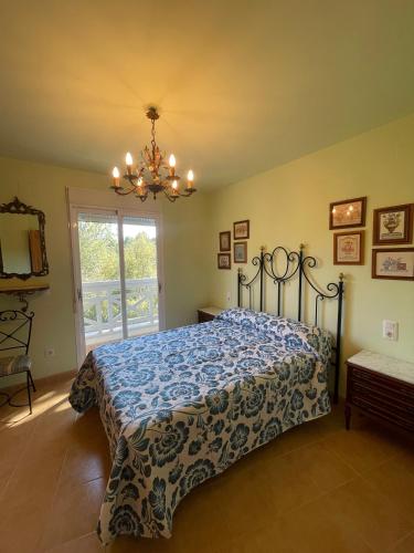 a bedroom with a bed and a chandelier at Alpen1 Residencial Edison in Peniscola