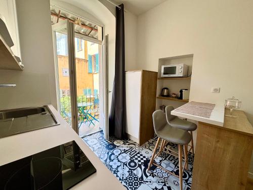 une cuisine avec une table et une chaise dans une pièce dans l'établissement Casamea - Studio, Terrasse, Clim, Centre hist, à Ajaccio