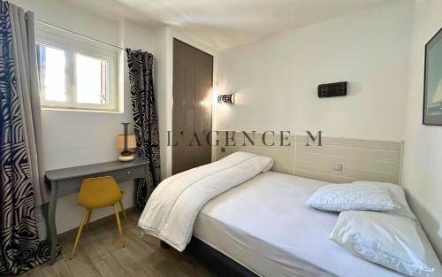 une chambre avec un lit, un bureau et une fenêtre dans l'établissement Appartement Colomba, à Calvi