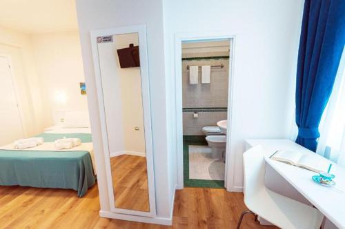 a bathroom with a mirror and a bed and a toilet at CVM Mare Luna in Maiori
