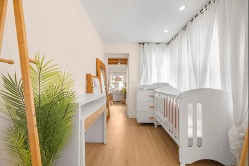 a white nursery with a crib and a white crib at Luxury on the beachfront in El Campello