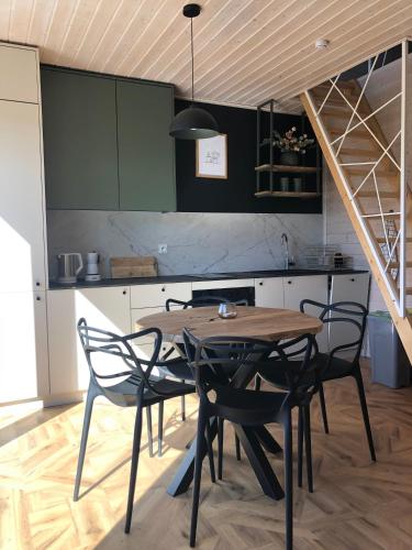 a kitchen with a wooden table and chairs in a room at Przylesie Domki in Wysoczany