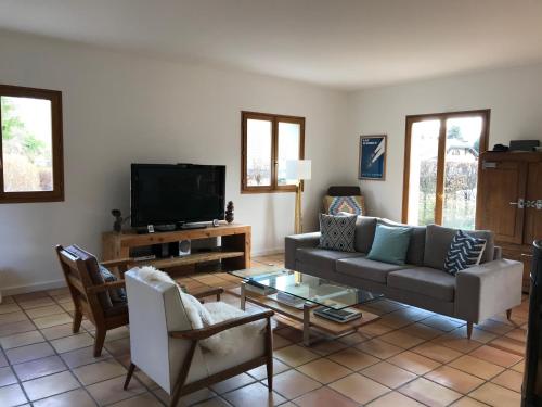 un salon avec un canapé et une télévision dans l'établissement Lovely Gated Family Home, Steps to the Lake, à Menthon-Saint-Bernard