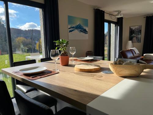 - une table à manger avec des verres à vin et une vue dans l'établissement villa du lac, à Aiguebelette-le-Lac