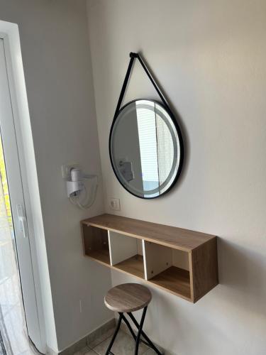a mirror hanging on a wall next to a table at Dream Apartments in Palaiochóra