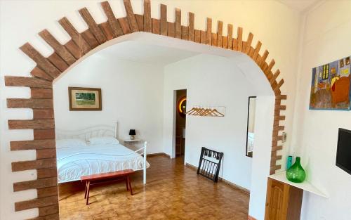 a bedroom with an archway with a bed and a table at Stefania Guest House in Giba