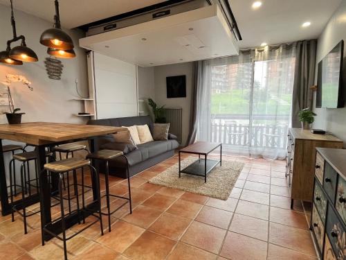 une cuisine et un salon avec un canapé et une table dans l'établissement Studio moderne au pied des pistes, emplacement idéal, central et calme, à Saint-Étienne-en-Dévoluy
