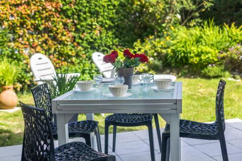 a table with chairs and a table with flowers on it at Appartement Iris - Welkeys in Ciboure
