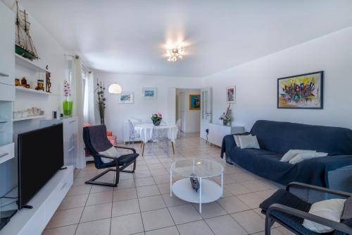 a living room with a blue couch and a table at Appartement Iris - Welkeys in Ciboure