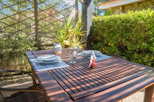a wooden picnic table with plates and glasses on it at Fattoria dei Piani srl in Olmedo