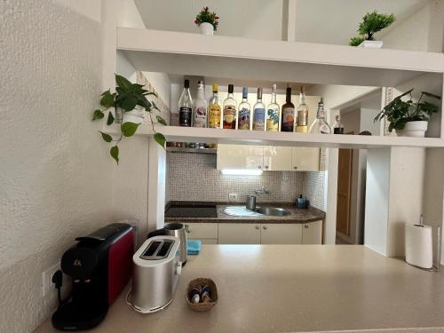 a kitchen with a counter with bottles of wine at Tili apartment with ocean view in San Marcos
