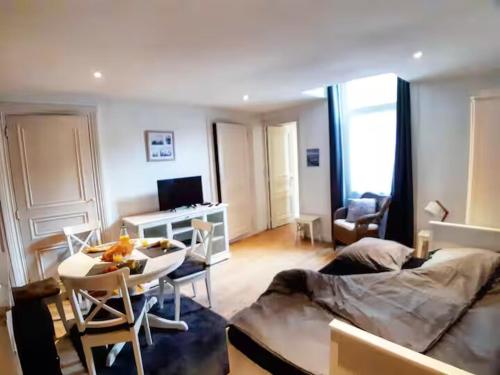 un salon avec un lit, une table et des chaises dans l'établissement La Coquille - Hypercentre Gare, à Saint-Brieuc