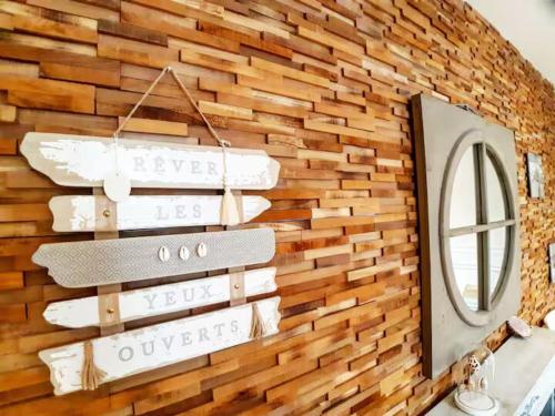 un mur en bois avec des planches de surf dessus avec un miroir dans l'établissement La Coquille - Hypercentre Gare, à Saint-Brieuc