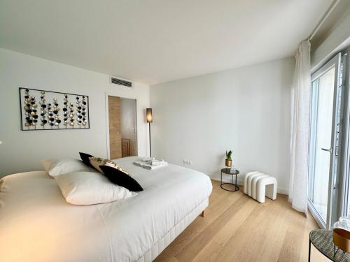 une chambre blanche avec un grand lit et une fenêtre dans l'établissement Patio Signature - Cœur de Reims, à Reims