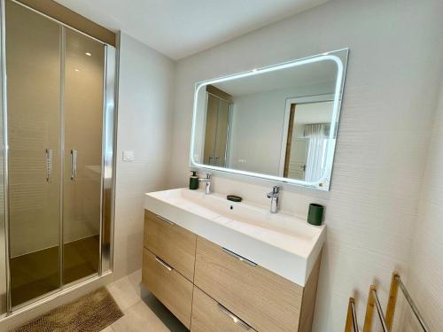 une salle de bain avec un lavabo et un miroir dans l'établissement Patio Signature - Cœur de Reims, à Reims