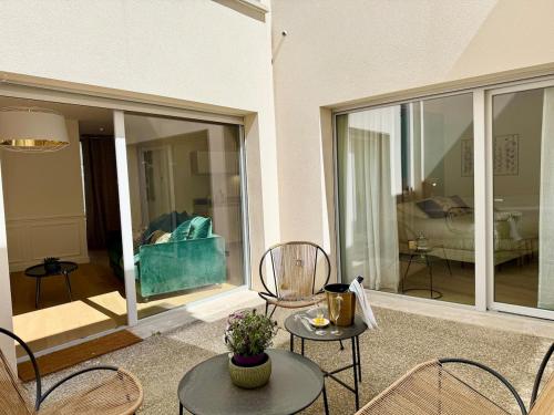 un patio avec des chaises et un canapé dans un salon dans l'établissement Patio Signature - Cœur de Reims, à Reims