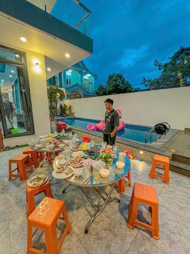 a man standing in front of a table with food on it at Minh Phuoc Villa Crystal in Vung Tau