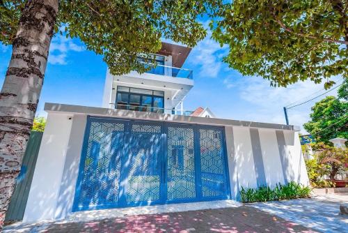 a house with a blue gate in front of it at Minh Phuoc Villa Crystal in Vung Tau
