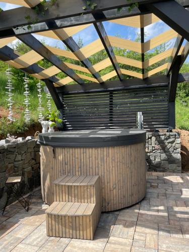 a pergola with a hot tub in a patio at A FRAME 1 TRANSALPINA in Petreşti