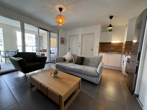 un salon avec un canapé et une table basse dans l'établissement CityLodge Marianne climatisation terrasse, à Montpellier