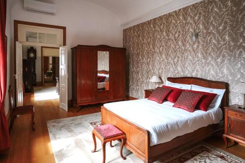a bedroom with a bed with red pillows at Boanova Guesthouse Convento Cucujães in Oliveira de Azemeis