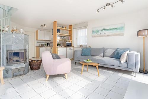 a living room with a couch and a fireplace at Meerkieker in Albertsdorf