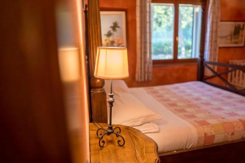 a lamp sitting on a table next to a bed at Fattoria dei Piani srl in Olmedo