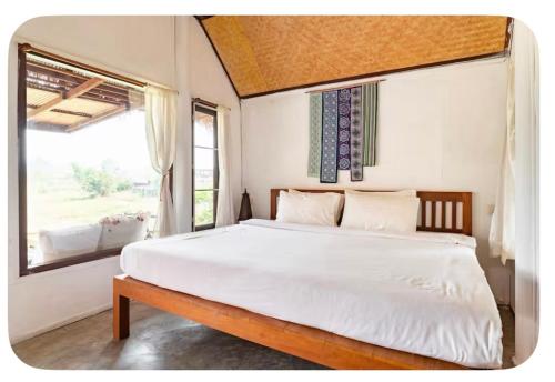 una camera da letto con un letto grande con una grande finestra di Bulun Buri Pai Resort a Pai