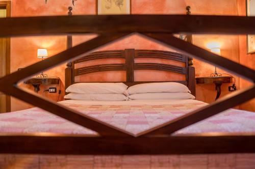 a wooden bed with white pillows in a room at Fattoria dei Piani srl in Olmedo