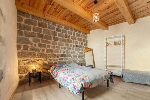 une chambre avec un lit dans un mur de pierre dans l'établissement Maison La Tour à Montréal, à Montréal