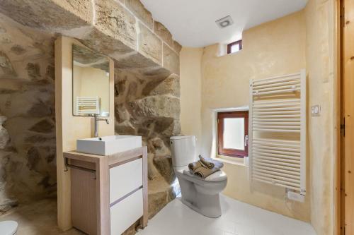 La salle de bains est pourvue de toilettes et d'un mur en pierre. dans l'établissement Maison La Tour à Montréal, à Montréal